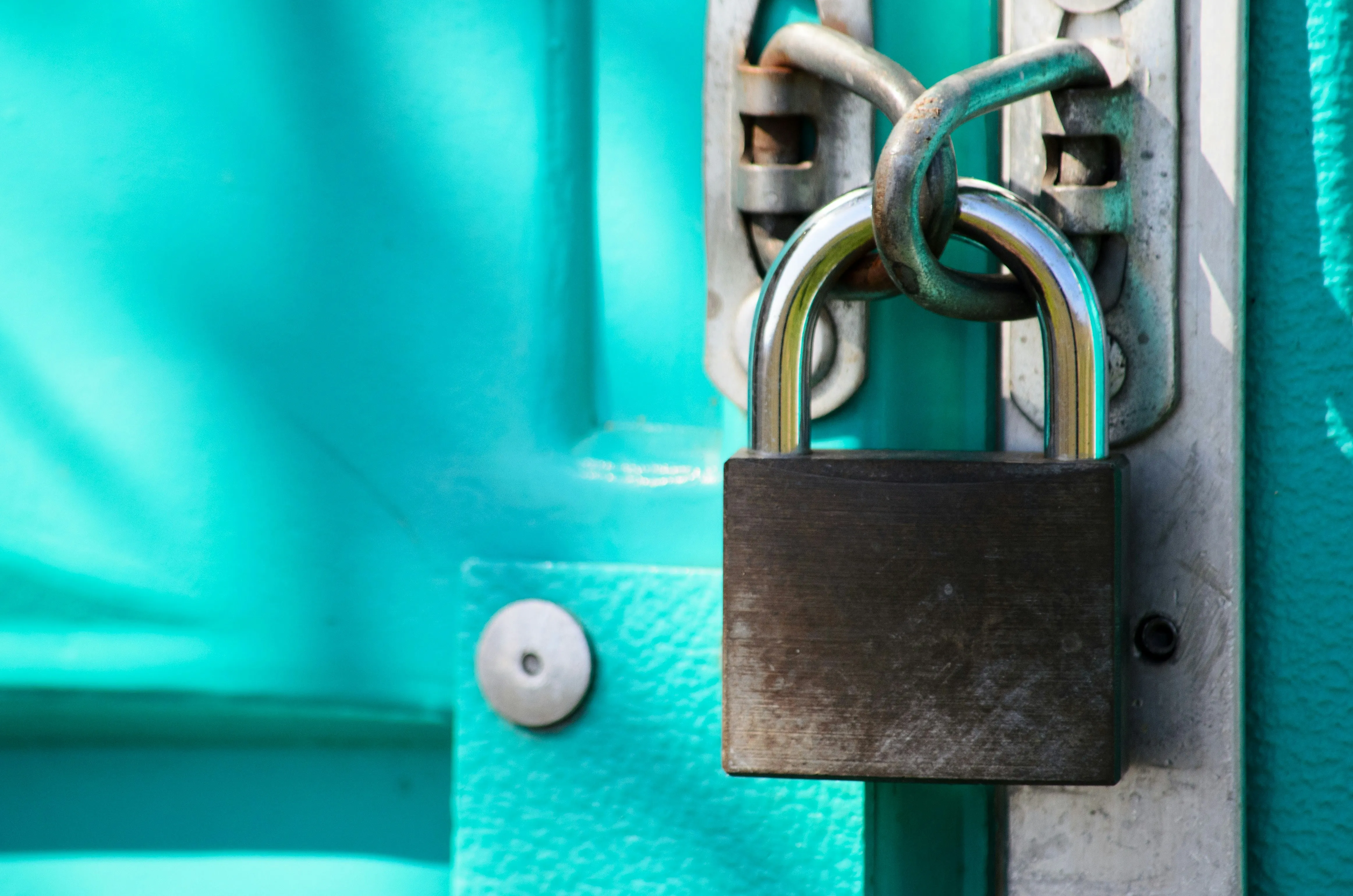 A rusty padlock secured the green door
